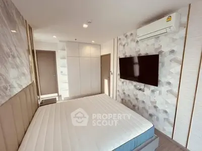 Modern bedroom with stylish decor and wall-mounted TV, featuring ample storage space.