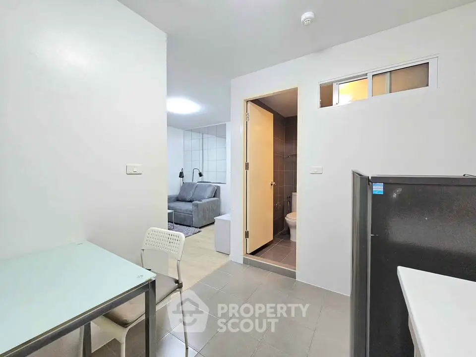 Modern apartment interior with open layout, featuring a cozy living area and compact kitchen.