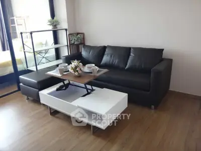 Modern living room with sleek black sofa and stylish coffee table, perfect for urban living.