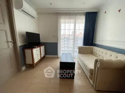 Charming living room with elegant sofa and TV, featuring a bright window view.