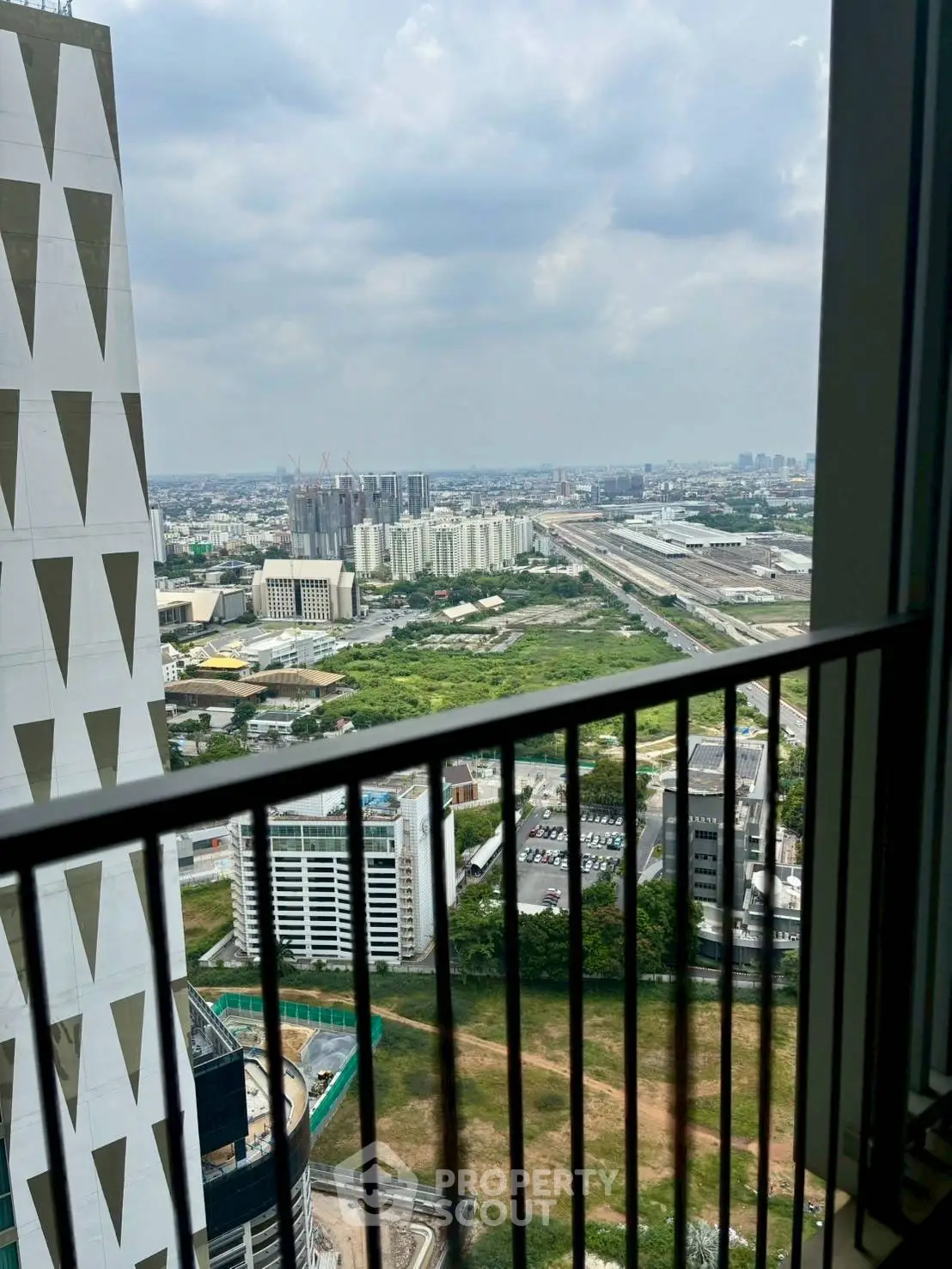 Stunning cityscape view from high-rise balcony with modern architecture.