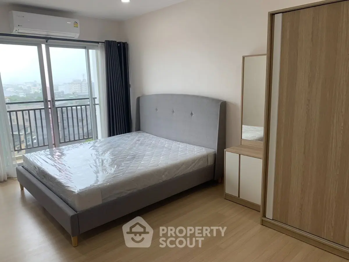 Modern bedroom with balcony view and stylish furniture in a high-rise apartment.