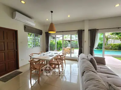 Spacious living room with pool view and elegant dining area