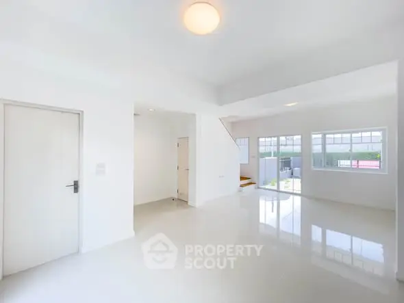 Spacious and bright living room with large windows and glossy floors