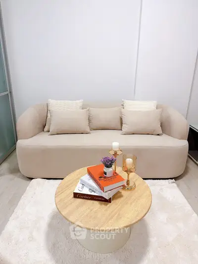 Stylish modern living room with cozy beige sofa and elegant round coffee table.