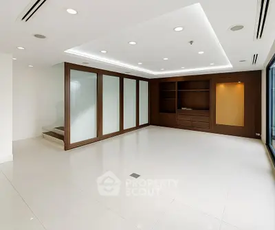 Spacious modern living room with elegant wooden accents and ample natural light.