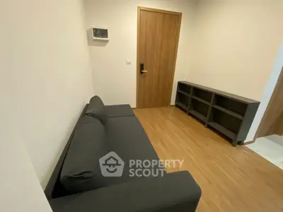 Modern minimalist living room with sleek black sofa and wooden flooring