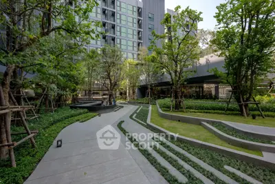 Modern apartment building with lush landscaped garden and walking paths.
