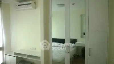 Cozy bedroom with mirrored wardrobe and air conditioning unit in modern apartment.