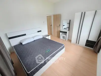 Spacious bedroom with modern furniture and ample natural light