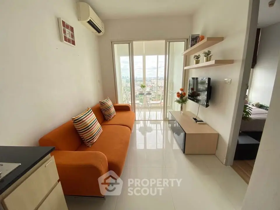 Modern living room with orange sofa, wall-mounted TV, and balcony view in a stylish apartment.