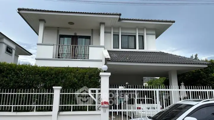 Modern two-story house with gated entrance and carport in suburban neighborhood.