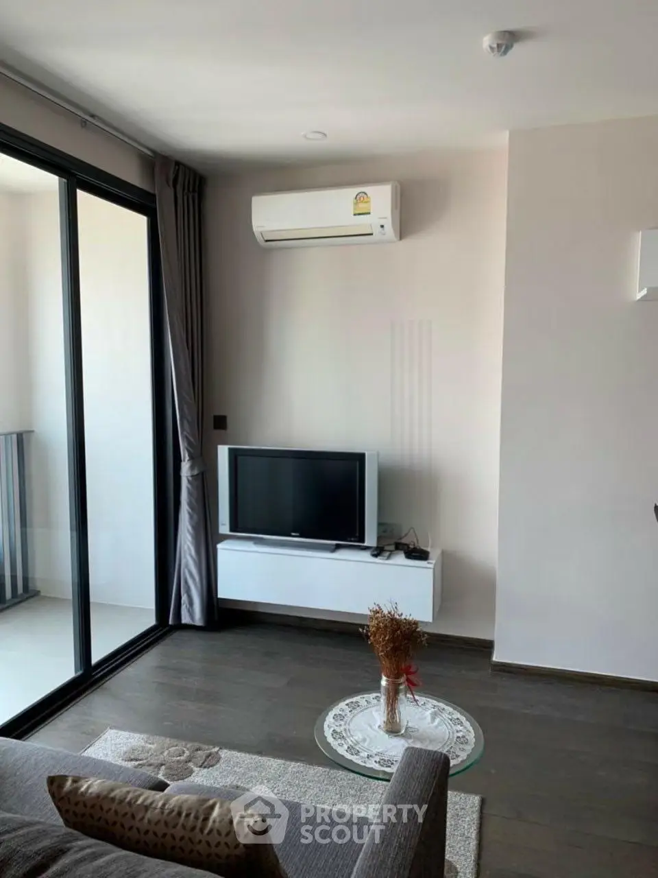 Modern living room with balcony access and air conditioning in a stylish apartment.
