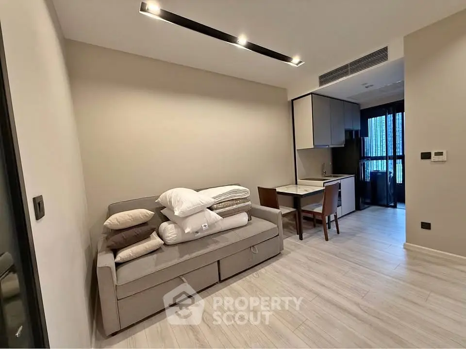 Modern studio apartment with sleek kitchen and cozy living area, perfect for urban living.