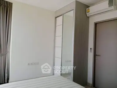 Modern bedroom with mirrored wardrobe and air conditioning unit