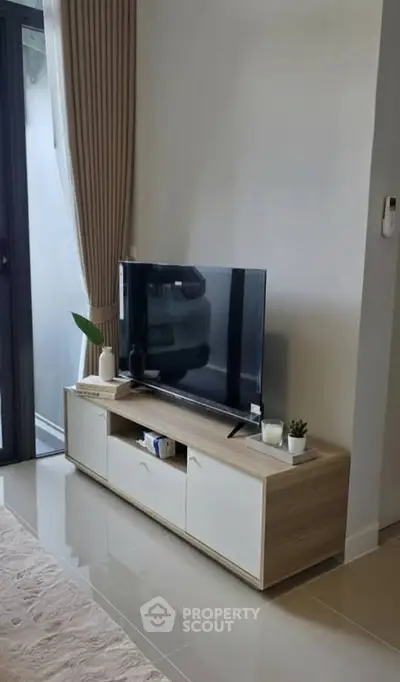 Modern living room with sleek TV stand and large window for natural light.