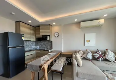 Modern open-plan kitchen and living room with stylish decor and natural light.