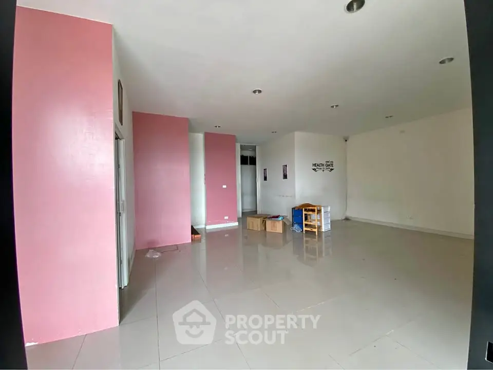 Spacious empty room with pink accent walls and tiled flooring, ideal for customization.