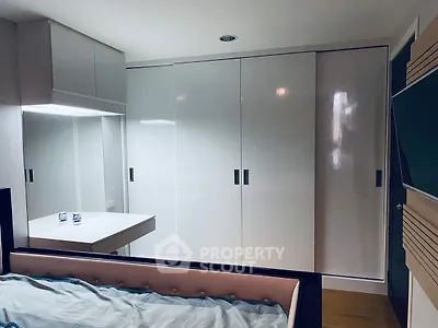 Modern bedroom with sleek white wardrobes and cozy bed setup