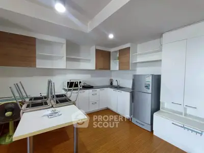 Modern kitchen with sleek cabinets and stainless steel fridge in a stylish apartment.