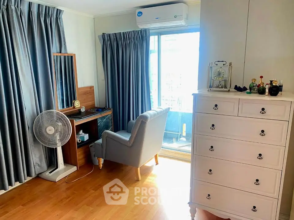 Cozy bedroom with elegant dresser and balcony access, featuring natural light and modern decor.