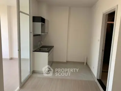 Modern minimalist kitchen with sleek cabinetry and open layout in a bright apartment.