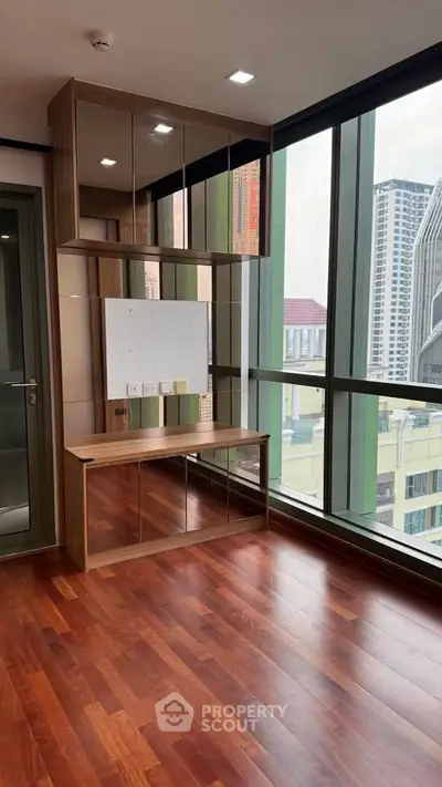 Modern study area with large windows and wooden flooring in high-rise apartment