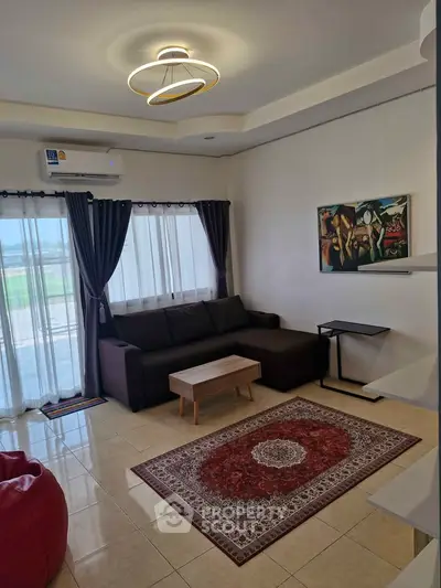 Elegant living room with modern decor, featuring a cozy sofa, stylish rug, and contemporary lighting.