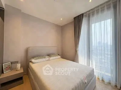 Modern bedroom with large window and city view, featuring elegant decor and natural light.