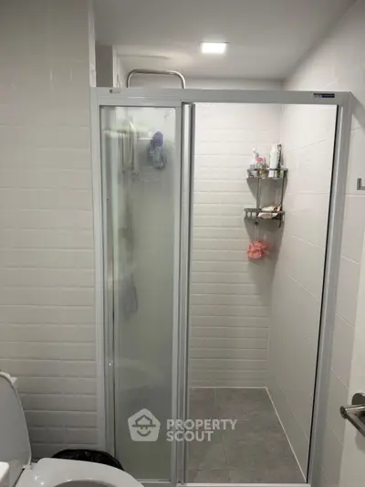 Modern bathroom with glass shower door and tiled walls