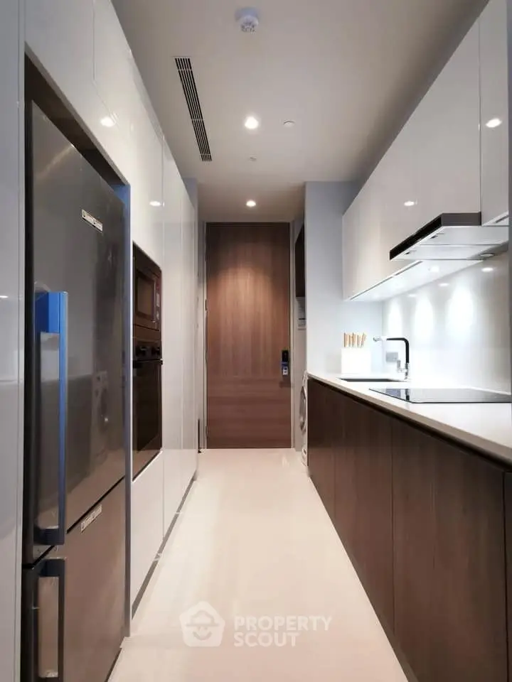 Modern kitchen with sleek cabinetry and stainless steel appliances in a contemporary apartment.