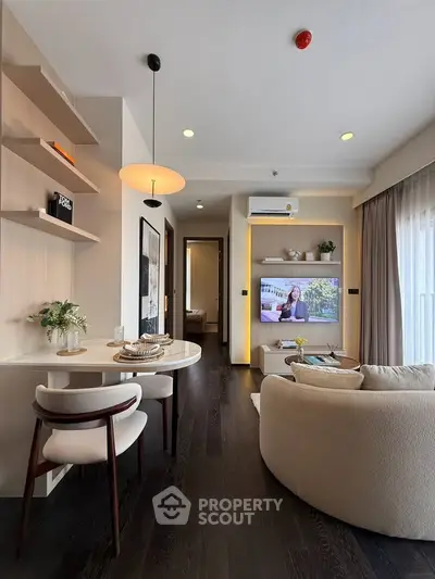 Modern living room with elegant dining area and cozy seating, featuring stylish decor and natural light.