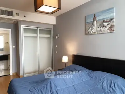 Cozy bedroom with modern decor and sliding closet doors in a stylish apartment.
