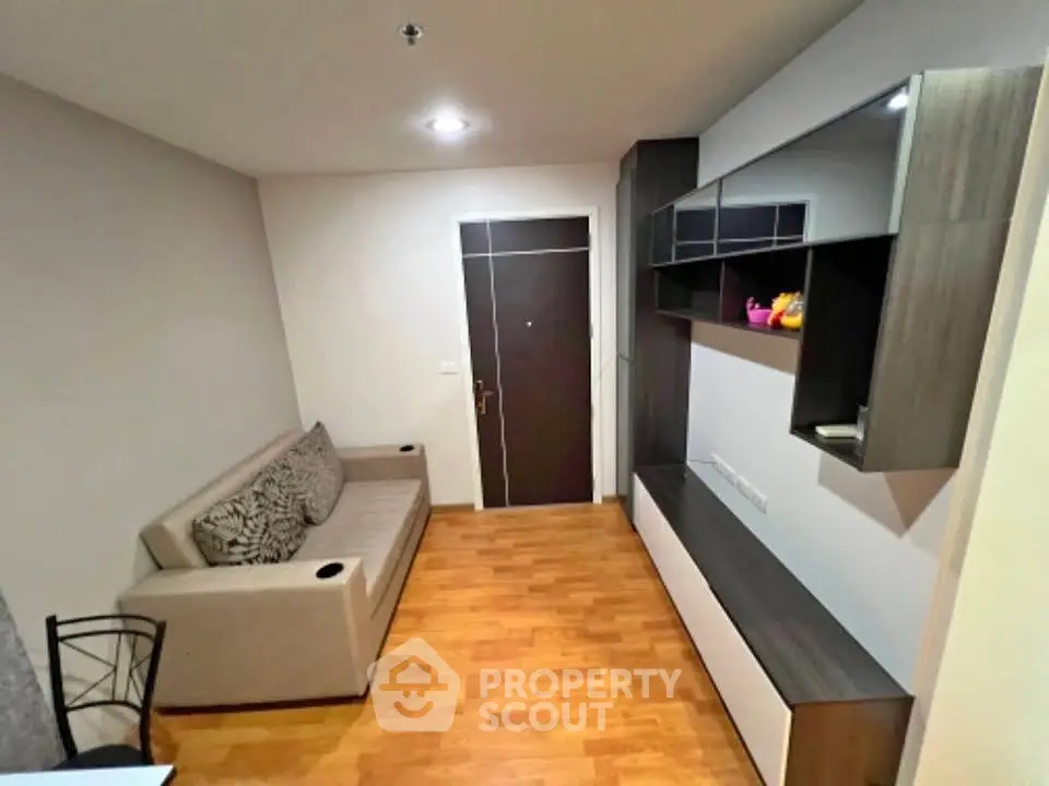 Modern living room with sleek furniture and wooden flooring in a cozy apartment.