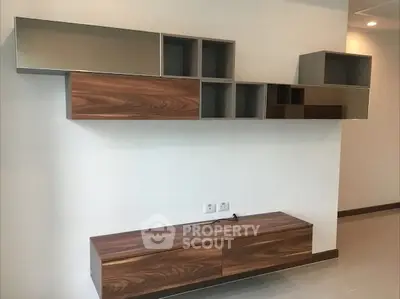 Modern living room with stylish wooden wall-mounted shelves and sleek design.