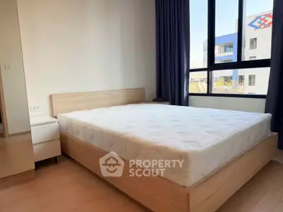 Spacious bedroom with large window and modern furnishings