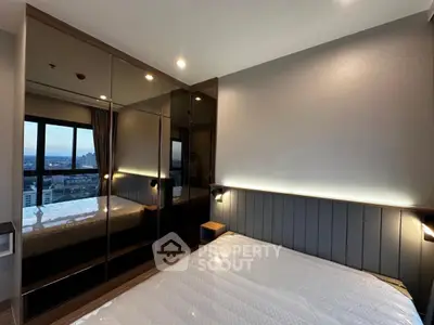 Modern bedroom with large mirrored wardrobe and city view window