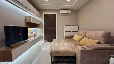 Modern living room with cozy sofa, sleek TV setup, and ambient lighting for a stylish home experience.