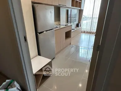 Modern living room with sleek wooden cabinetry and large windows offering natural light.