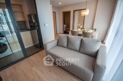 Modern open-plan living room with kitchen and dining area in stylish apartment