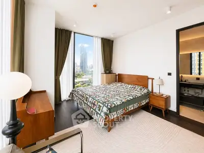 Luxurious bedroom with stunning city view and modern furnishings in high-rise apartment.