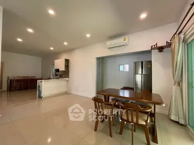 Spacious open-plan living and dining area with modern kitchen and natural light.