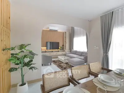 Modern living room with stylish decor and open layout, featuring a cozy seating area and elegant dining space.