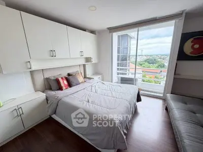 Spacious bedroom with large windows offering stunning city views and modern furnishings.