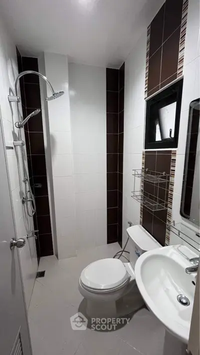 Sleek modern bathroom with wall-mounted shower, ceramic fixtures, and stylish brown accent tiles, perfect for contemporary living.
