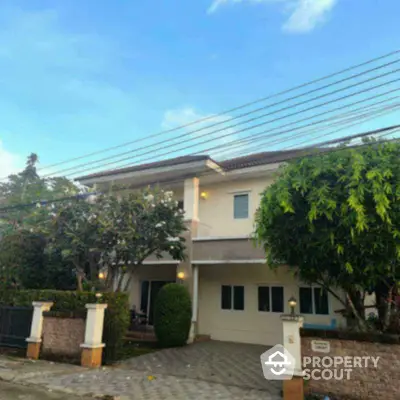 Charming two-story house with lush garden and spacious driveway in serene neighborhood.