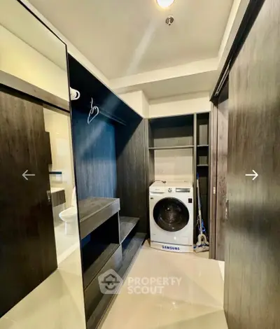Modern laundry room with Samsung washing machine and sleek storage cabinets.