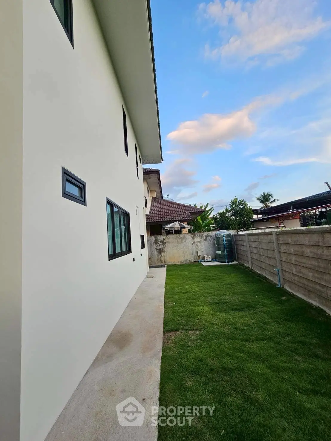 Modern house exterior with spacious backyard and lush green lawn