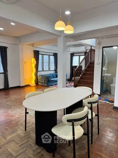 Spacious open-plan living and dining area with modern decor and stylish lighting.