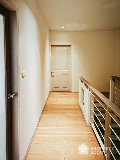 Bright hallway with wooden flooring and modern railing in a stylish home